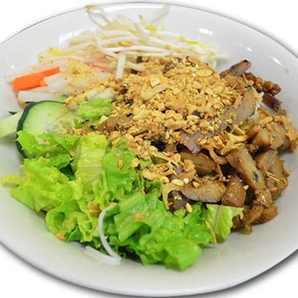 A bowl of Yummy Deli's grilled pork salad with lettuce, bean sprouts, and crushed peanuts.